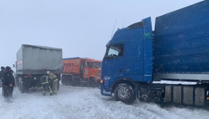 Через снігопад на важливій трасі застрягли близько сотні вантажівок